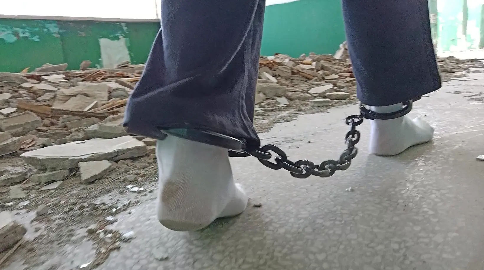 戴着脚镣在废墟里光脚和穿白袜散步